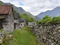 Steindörfer im Valle Maggia, umgeben von grünen Bergen und bewachsenen Mauern.
