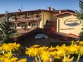 Hotel Pod Szrenicą w Szklarskiej Porębie, otoczony zielenią i kwitnącymi kwiatami, zaprasza na wypoczynek.