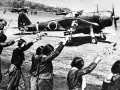 Des jeunes Japonais agitent des fleurs vers un avion, peut-être un adieu avant une mission kamikaze.