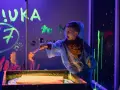 Chłopiec w neonowych barwach tworzy sztukę w ciemni. Świetne atrakcje dla dzieci w Szczecinie!