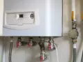 Caldaia a gas con pannello di controllo e tubazioni. Il tubo scarico fumi scaldabagno a gas normativa è essenziale per la sicurezza.