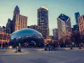 Reflections of the Chicago skyline shimmer on the iconic Cloud Gate sculpture. A perfect snapshot of Chicago in a day, with people enjoying the evening.