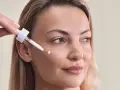 Kwas palmitynowy w kroplach serum pielęgnuje skórę kobiety, nadając jej blask.