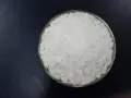 Schale mit weißen Pellets, die Natriumhydroxid darstellen.