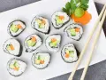 Talerz sushi z awokado, ogórkiem i marchewką. Czy sushi jest kaloryczne? Zależy od składników, ale te warzywne rolki wyglądają lekko!