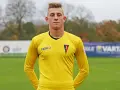 Młody bramkarz Michał Hoffmann w żółtej koszulce z herbem Pogoni.