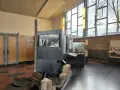 Ausstellung im "Palace of Tears" Berlin: Ein Stein, ein Bildschirm mit historischem Bild, und Ausstellungsstücke erinnern an die Teilung.