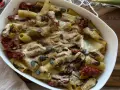 Piatto di pasta con carciofi alla siciliana, pomodori secchi e semi di zucca, gratinata al forno.
