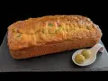 Un délicieux cake jambon olive, doré et moelleux, servi avec deux olives vertes sur une cuillère.