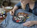Dziewczyna maluje na dżinsowej kurtce czaszkę z płomieniami i napisem "ROCK". Czy farba akrylowa nadaje się do tkanin? Tak, jak widać na zdjęciu!