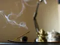 Dym z kadzidła unosi się w domu, tworząc mistyczną atmosferę podczas chwili zadumy i modlitwy.
