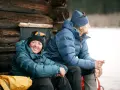 Zwei Personen in warmen 700 cuin Daunenjacken genießen eine Pause im Freien. Die Jacken halten sie bei kühler Temperatur angenehm warm.
