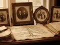 Un arbre généalogique alsacien, entouré de vieilles photos de famille et de documents jaunis, évoque le passé.