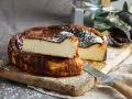 Tarta de queso La Viña, receta auténtica con su interior cremoso y exterior caramelizado, espolvoreada con azúcar glas.