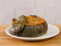 Deliziosa zucca ripiena, con un appetitoso ripieno dorato che fuoriesce dal suo guscio cotto.