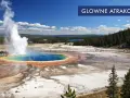 Wielobarwny gorący źródło z wyrzucającą parę wodą w **parku narodowym Yellowstone**. Turyści spacerują po drewnianych kładkach, podziwiając cuda natury.
