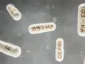 Flera kapslar med texten "D3 + K2" svävar i luften. Dessa kapslar kan vara ett komplement till din k vitamin mat.
