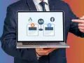Biznesmen prezentuje test A/B kampanii PPC na laptopie, porównując Google Ads z Facebookiem.