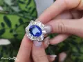 Anello con una preziosa pietra azzurra al centro, circondata da diamanti a baguette e taglio brillante.