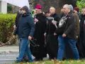 Grupa mężczyzn, w tym biskup, idzie ulicą. Niektórzy niosą różańce, jak rycerze Maryi.