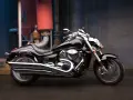 Czarny Suzuki Boulevard 1800 lśni w blasku przemysłowego otoczenia. Potężny silnik i chromowane detale przyciągają wzrok.