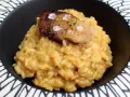 Cremoso risotto a la milanesa, coronado con un trozo crujiente y salpicado de sal marina y hierbas.