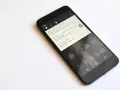 Czarny smartfon z powiadomieniem o pobraniu aktualizacji systemu Android 7.0 Nougat.