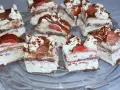 Pyszne ciasto z bitą śmietaną, czekoladą i truskawkami, pokrojone na kawałki.