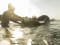 Ein Mann hilft einer Frau mit einem Schwimmring im Wasser. Ein sonniger Tag am Badesee Braunschweig.