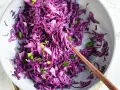 Insalata fresca e colorata di cavolo cappuccio rosso, condita con erbe aromatiche, pronta per essere gustata.