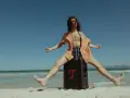 Mężczyzna na plaży skacze na głośniku, słuchając stare piosenki na lato.