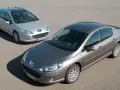 Dwa samochody Peugeot 407, sedan i kombi, na drodze. Wiele osób chwali sobie te modele, a opinie o Peugeot 407 są zazwyczaj pozytywne.