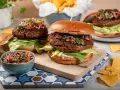 Dwa soczyste burgery z awokado i salsą. Idealna sałata do burgera to ta chrupiąca, zielona, która dodaje świeżości.
