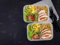 Dwa pudełka na lunch do pracy: kurczak faszerowany, kasza, sałatka z pomidorkami i kiełkami, kiwi i mango.