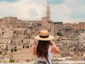 A woman in a straw hat captures the ancient city of Matera, a highlight of her southern tour of Italy.