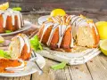 Najlepsza babka cytrynowa wilgotna na oleju, ozdobiona lukrem i skórką cytrynową, z kawałkami na talerzykach.