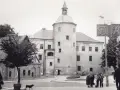 Zamek książąt pomorskich w Słupsku, z charakterystyczną wieżą i arkadowym balkonem, na tle miejskiego krajobrazu.