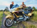 Złoty Honda Goldwing 1800 na polnej drodze, dwaj mężczyźni dyskutują o jego wadach.