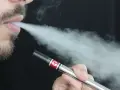 Hombre vapeando con un dispositivo Vuse, exhalando vapor. Una opción para quienes buscan vapers sin nicotina y cuidan su salud.