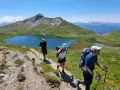 Trois randonneurs progressent sur un sentier de montagne, profitant d'un paysage spectaculaire. Ils sont en plein tour du Queyras 4 jours.