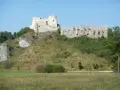 Ruiny zamku na wzgórzu, część szlak orlich gniazd trasa. Kamienne mury i wieże górują nad zielonym krajobrazem.