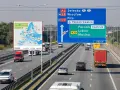 Mapa Europy z limitami prędkości na autostradach i znak drogowy z kierunkami jazdy.