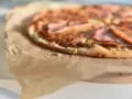 Apetyczna pizza na papierze do pieczenia. Zastanawiasz się, ile kcal ma pizza 40 cm? Ta wygląda na pyszną!