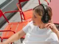 Femme aux taches de rousseur écoutant de la musique avec des écouteurs, un exemple de 85 dB pour une immersion sonore.