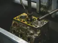 Precyzyjne honowanie cylindra silnika, z płynem chłodzącym wylewającym się na metal.