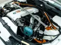 Custom BMW engine bay with a silver strut bar and orange accents. If your engine is ticking, check the oil level and listen for unusual noises.
