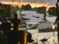 Storforsen camping: en brusande fors i solnedgången, med skog och träd som ramar in. Mysig belysning i förgrunden.