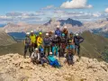 Grupa turystów w sprzęcie wspinaczkowym pozuje na tle górskich krajobrazów Dolomitów. To wspaniała przygoda na via ferrata Dolomity!