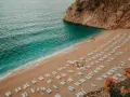 Piękna plaża z leżakami i turkusową wodą. Idealne miejsce, by zapytać: Turcja gdzie na wakacje?