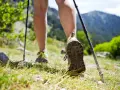 Nauka jak chodzić z kijkami to klucz do stabilności na górskim szlaku. Widok na nogi w butach trekkingowych i kijki wspierające marsz.